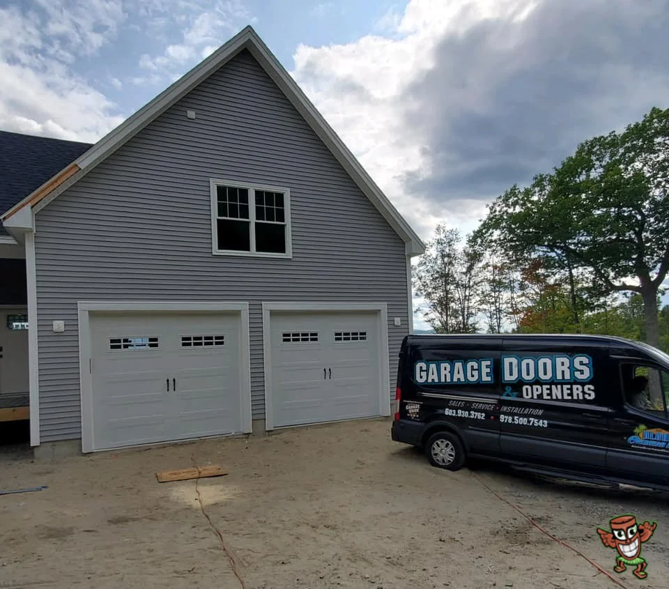 A service van parked in front of a home with two white garage doors, representing a Residential Overhead Door Company.